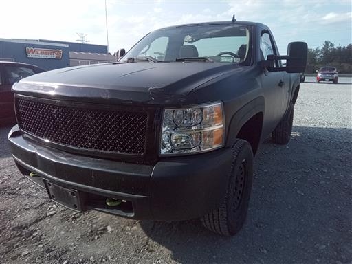 Black Chevrolet Silverado truck parked at Wilbert’s auto salvage lot.