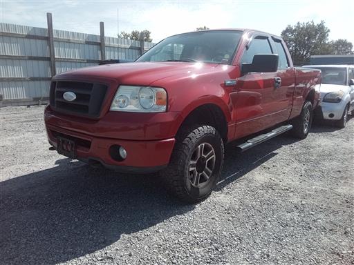 Red Ford F-150 extended cab pickup truck on gravel lot.